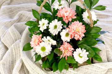 Orange chrysanthemums and daisy flower, beautiful bouquet of flowers in wicker basket