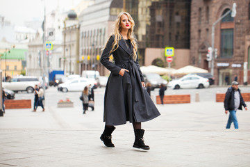 Fototapeta premium Portrait of a young beautiful woman in gray coat