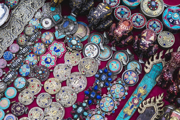 Colorful traditional buddhist souvenirs are sold on the tourist market in Kathmandu, Nepal. Contain of ornaments, small figures, jewelry, statues, masks, prayer whells.