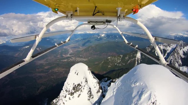 View From Large Valley Traveling High Speed Above Glacier Mountain Peak in Helicopter POV Angle Looking Backwards