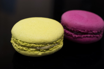 Macaroni cakes on black background. Close-up.