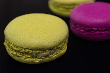 Macaroni cakes on black background. Close-up.