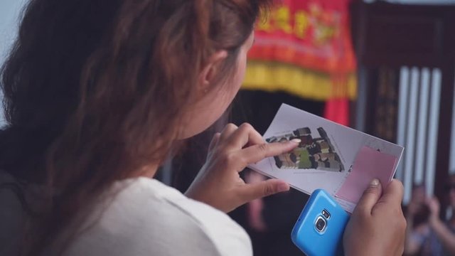 A tourist girl looks at the map of the museum, wants to find a way out. slow motion. 1920x1080. full hd