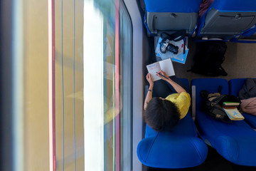 young woman loking in diary and writing words travel blog train during her traveling view from...