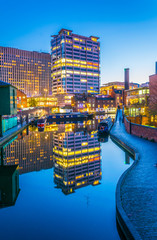 Sunset view of brick buildings alongside a water channel in the central Birmingham, England