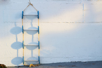 Fototapeta na wymiar Conceptional background of blue marine ladder leaning against white wall