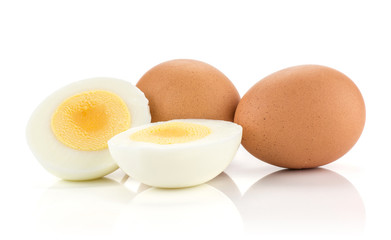Two brown chicken eggs with boiled sliced halves isolated on white background.