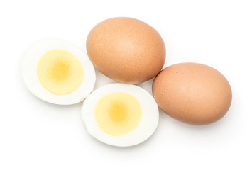 Two brown chicken eggs with boiled sliced halves top view isolated on white background.