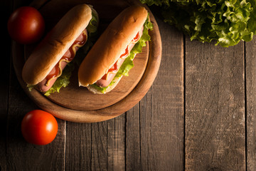 Photo of barbecue grilled hot dog with yellow mustard and ketchup on wooden background. Hot dog...