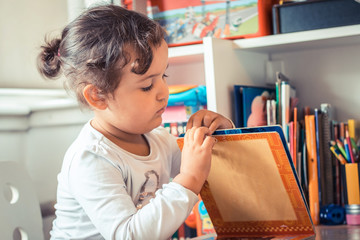 Little girl reading a book at kindergarten.