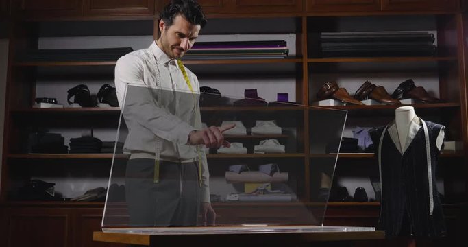 Portrait of a handsome man in a sewing using a futuristic computer.