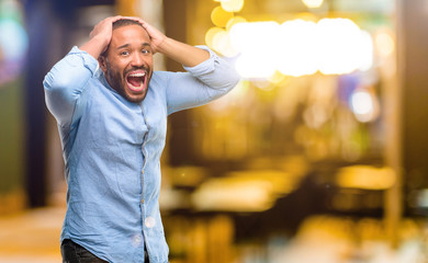 Fototapeta premium African american man with beard happy and surprised cheering expressing wow gesture at night