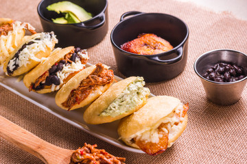 Different types of arepas, meat, black beans, cheese, fried plantain, typical South American food