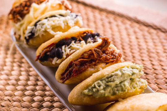 Different types of arepas, meat, black beans, cheese, fried plantain, typical South American food
