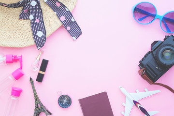 Woman's essentials, air plane model, passport and camera on pink pastel color background, Travel vacation concept