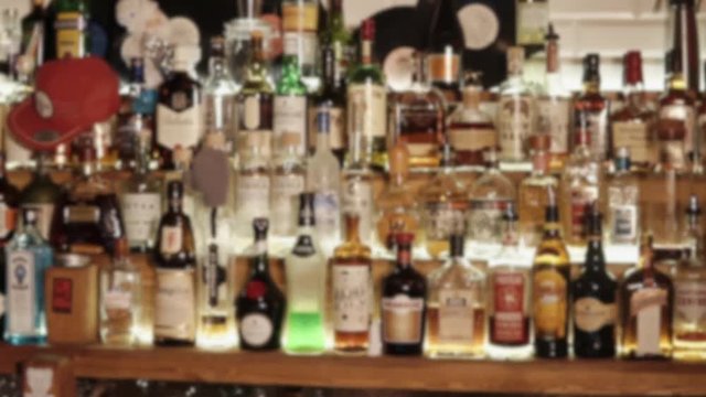 Spirit drinks in bottles in a bar of night club. Camera is showing an assortment of alcoholic beverages