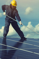 Obraz premium technician operating and cleaning solar panels at generating power of solar power plant; technician in industry uniform on level of job description at industrial