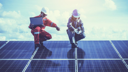 engineers operating and check generating power of solar power plant on solar rooftop; technical...