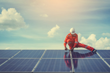 engineers repairing solar panel at generating power of solar power plant ; technician in industry uniform on level of job description at industrial