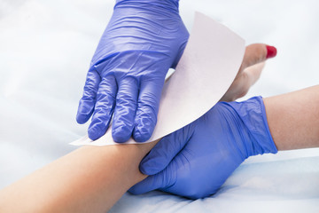 Obraz premium The process of classical wax depilation of female limbs in the beauty salon. 