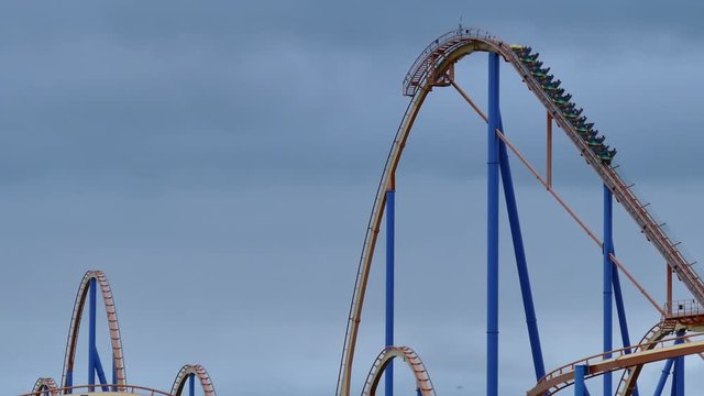 Roller coaster reaching top of drop hill