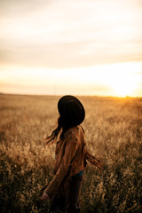 Boho nomads girl in field at Sunset