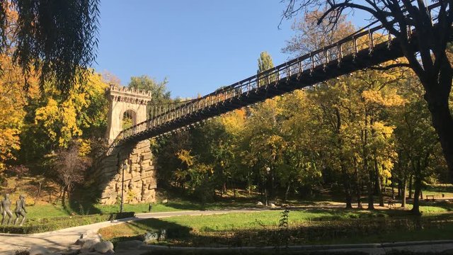 Beautiful day in Romanian park footage - Suspension bridge by autumn in city of Craiova
