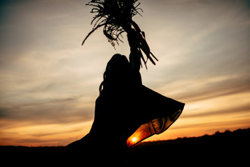 Boho nomads girl in field at Sunset