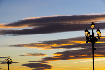 Lighted lanterns against the backdrop of the setting sun on the streets of Madrid