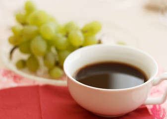 Cup of natural coffee with grapes