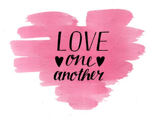 Hand lettering Love one another on watercolor heart.