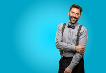 Middle age man, with beard and bow tie confident and happy with a big natural smile laughing