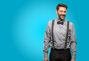 Middle age man, with beard and bow tie confident and happy with a big natural smile looking side