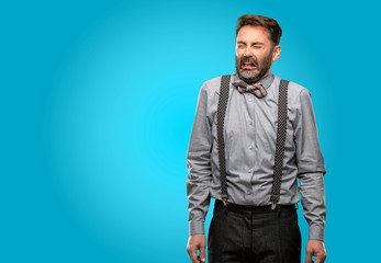 Middle age man, with beard and bow tie crying depressed full of sadness expressing sad emotion