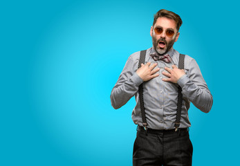 Middle age man, with beard and bow tie happy and surprised cheering expressing wow gesture
