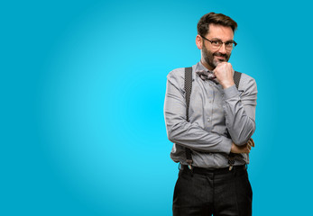 Fototapeta premium Middle age man, with beard and bow tie thinking thoughtful with smart face, expressing question and doubt. Imagine the solution