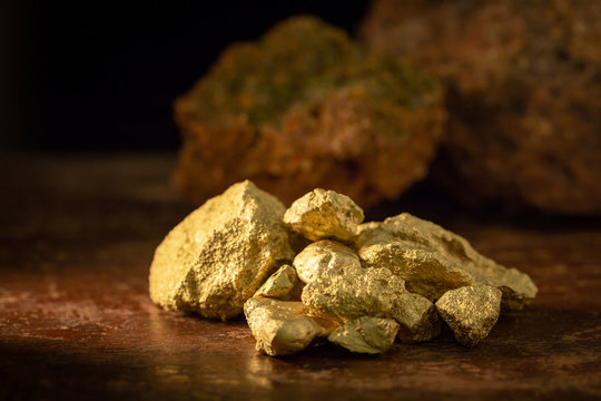 Gold nugget grains on a wooden table