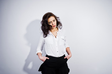 Studio portrait of brunette girl in white blouse on white background.