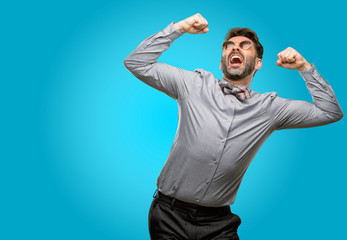 Middle age man, with beard and bow tie happy and excited celebrating victory expressing big success, power, energy and positive emotions. Celebrates new job joyful