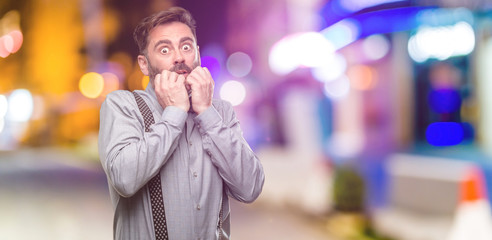 Middle age man, with beard and bow tie terrified and nervous expressing anxiety and panic gesture, overwhelmed at night club