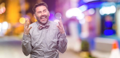 Naklejka premium Middle age man, with beard and bow tie terrified and nervous expressing anxiety and panic gesture, overwhelmed at night club
