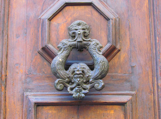Unusual door knockers are one of the ways to decorate the entrance doors of the wealthy townspeople of Florence in the Middle Ages. Florence, August 2014.