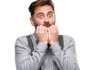 Middle age man, with beard and bow tie terrified and nervous expressing anxiety and panic gesture, overwhelmed isolated over white background