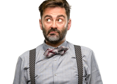 Middle age man, with beard and bow tie doubt expression, confuse and wonder concept, uncertain future isolated over white background
