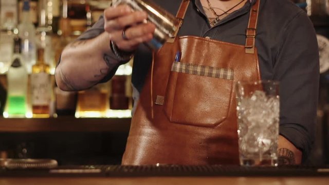Barman is flairing a drink in two shakers and mixing and demonstrating his skill. Tricks bartenders during working time in a restaurants