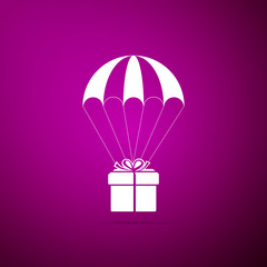 Gift box flying on parachute icon isolated on purple background. Delivery service, air shipping concept, bonus concept. Flat design. Vector Illustration