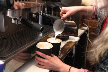Fototapeta na wymiar Barista making fresh takeaway coffee. Close-up view on hands with portafilter, barista coffee preparation service concept.
