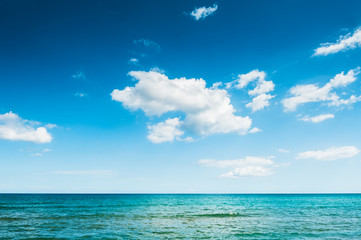 Blue sea and blue sky with clouds.