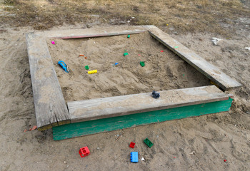 Abandoned sandbox with broken toys.