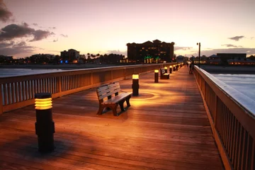 Photo sur Plexiglas Descente vers la plage Deerfield Beach, Florida Pier Boardwalk After Dusk with Lights Illuminated, Park Sitting Benches, Atlantic Ocean on Either Side and Hotels in the Distance